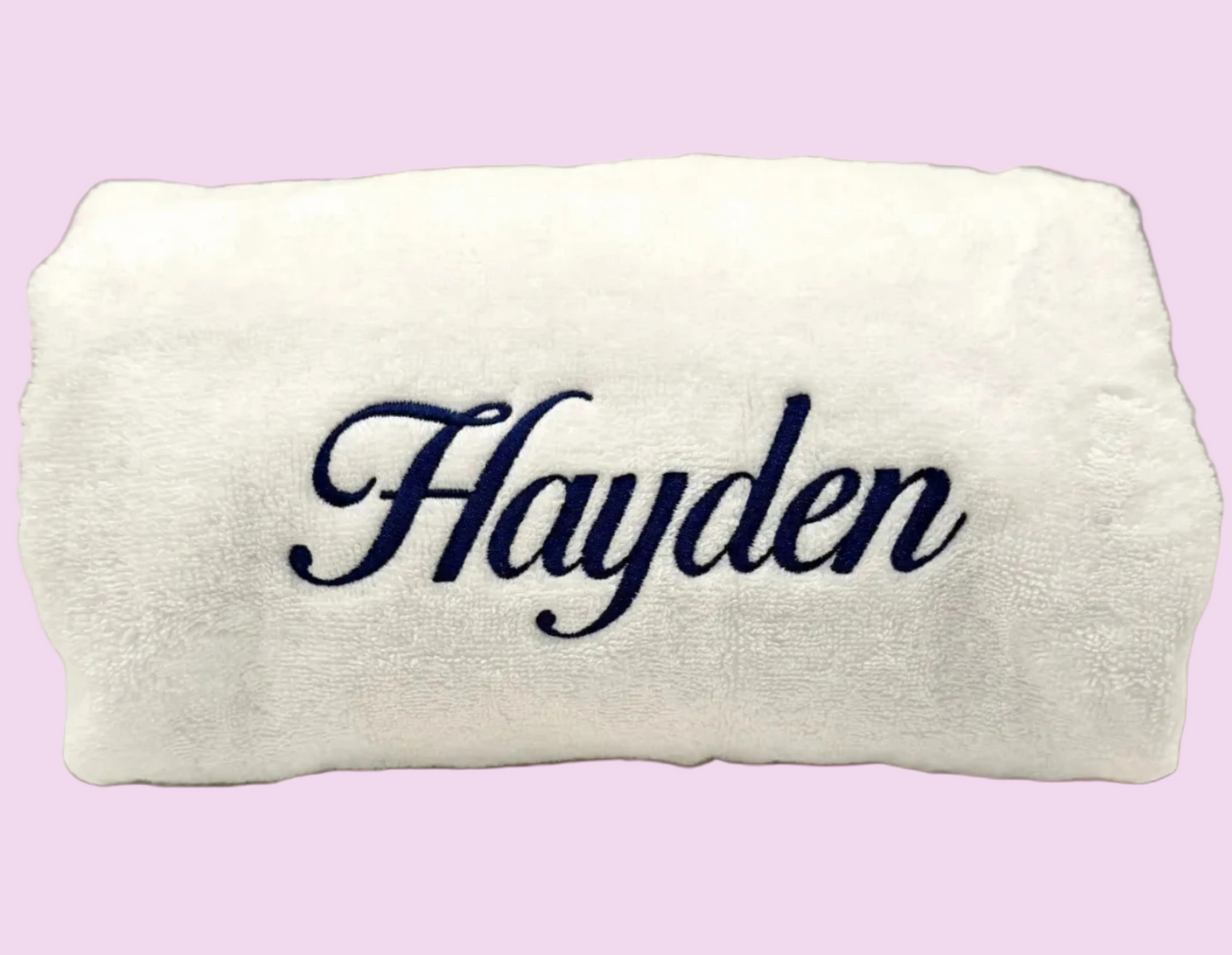 Terry cloth towel with the name 'Hayden' embroidered in dark navy script across the center, shown on a plain light background.