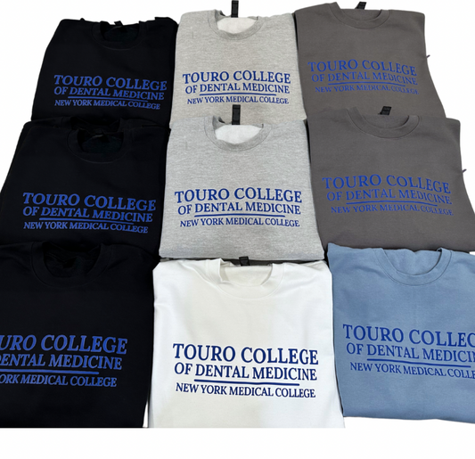 A collection of sweatshirts in black, gray, blue, and white, each with 'Touro College of Dental Medicine' printed on the front in blue or white text.