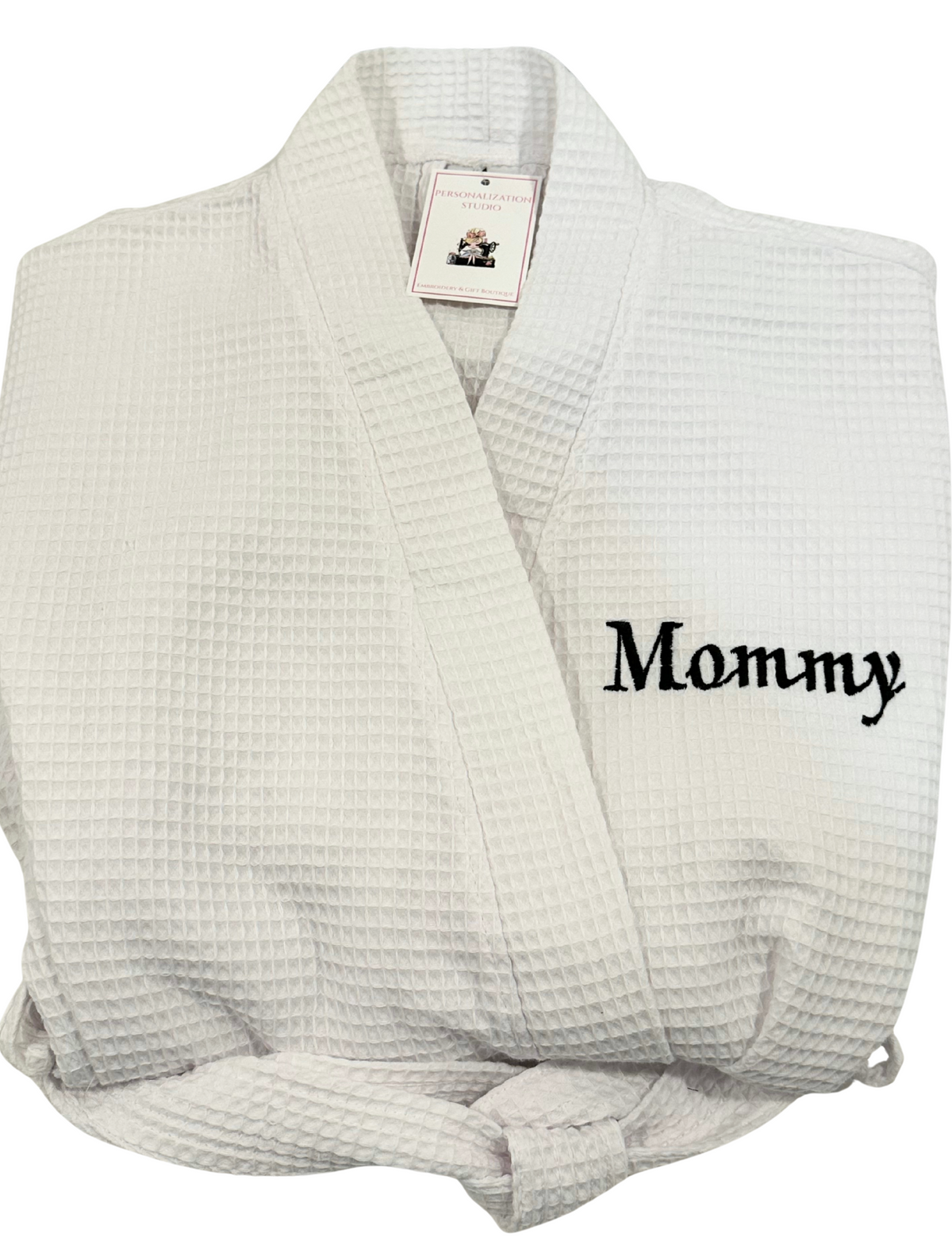 A white waffle-weave bathrobe embroidered with the word 'Mommy' embroidered in navy on the chest. Personalized embroidered robes are the best gifts for bridal showers, college gifts, birthday gifts or housewarming gifts.