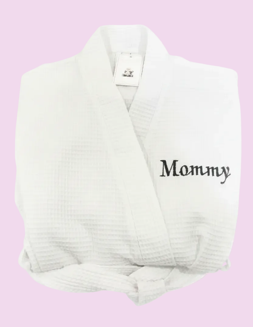 A white waffle-weave bathrobe with the word 'Mommy' embroidered in navy on the chest. Personalize this 36" robe for brides, gifts, moms, college gifts or for guest rooms. 