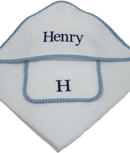 White hooded baby towel with blue gingham trim and embroidered name 'Henry' on a white background. 100 % terry cotton