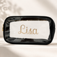 A clear cosmetic pouch personalized with name or monogram in permanent vinyl. available in black, cream or fushia with gold zipper.