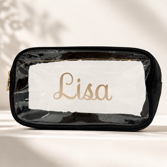 A clear cosmetic pouch personalized with name or monogram in permanent vinyl. available in black, cream or fushia with gold zipper.