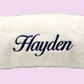 Terry cloth towel with the name 'Hayden' embroidered in dark navy script across the center, shown on a plain light background.