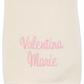 White blanket with pink embroidered text on a white background